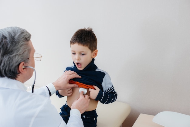 Ein kleiner Junge, der vom Arzt in der Klinik konsultiert wurde