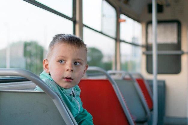 Ein kleiner Junge fährt alleine mit der Straßenbahn. Reise eines Kindes in öffentlichen Verkehrsmitteln