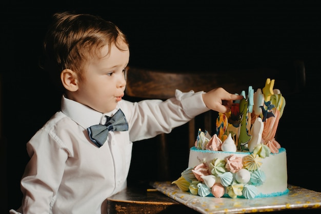 Ein kleiner Junge neben einem Kuchen zu seinem Geburtstag