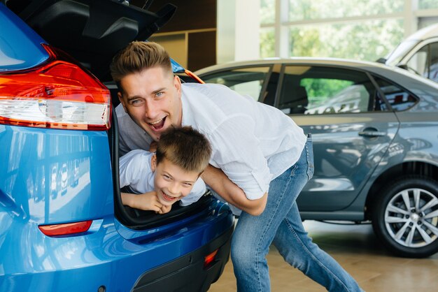 Foto ein kleiner junge sitzt im kofferraum, während seine eltern ein neues auto wählen.