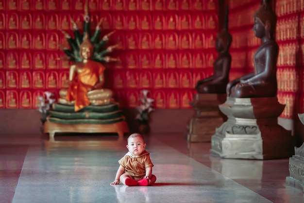 Ein kleiner Junge spielt glücklich in einem thailändischen Tempel.