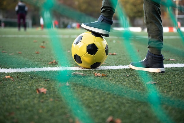 Ein kleiner Junge spielt mit seinem Vater auf dem Fußballfeld Fußball