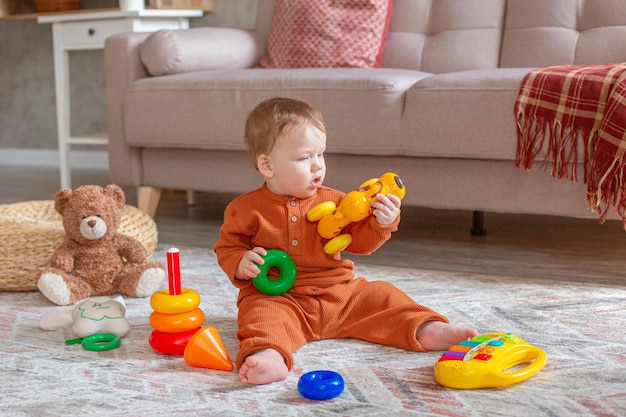 Ein kleiner Junge spielt mit Spielzeug auf dem Boden des Hauses