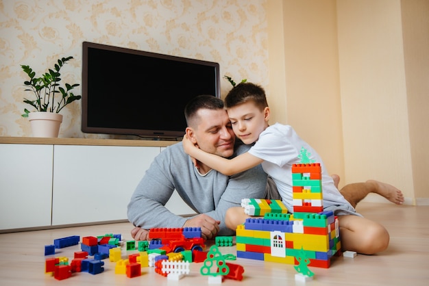 Ein kleiner Junge wird zusammen mit seinem Vater von einem Bauunternehmer gespielt und baut ein Haus