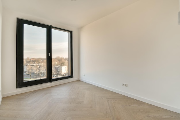 Ein kleiner leerer Raum in Weißtönen mit einem großen schwarzen Fenster in einem modernen Haus