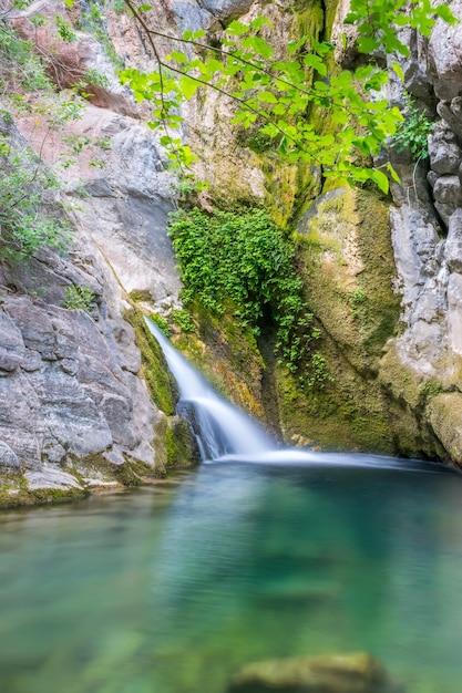 Ein kleiner malerischer Wasserfall in einer gemütlichen Berglagune.