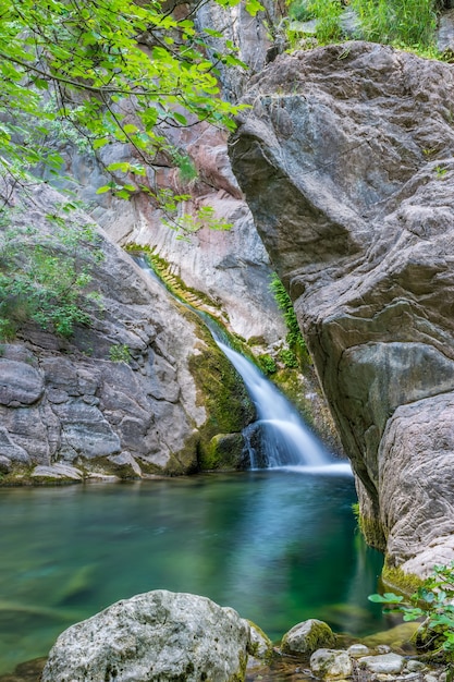 Ein kleiner malerischer Wasserfall in einer gemütlichen Berglagune.