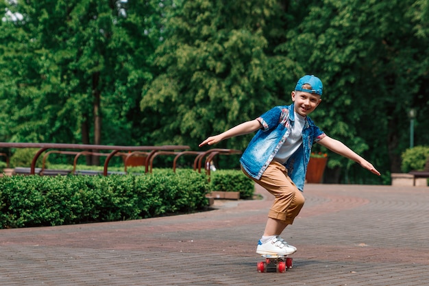 Ein kleiner Stadtjunge andskateboard. Ein junger Mann fährt auf einem Parka-Skateboard