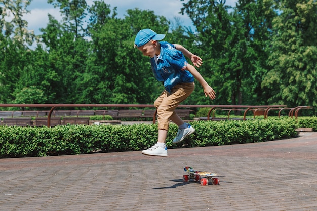 Ein kleiner Stadtjunge andskateboard. Ein junger Mann fährt auf einem Parka-Skateboard