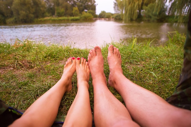 Ein kleines Campingzelt am See ist eine Übernachtungsmöglichkeit und die Füsse eines jungen Paares