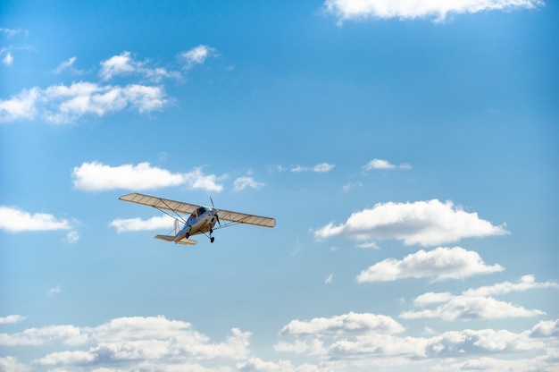 Ein kleines einmotoriges Flugzeug, das über den blauen Himmel fliegt