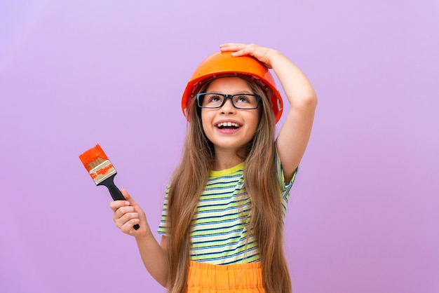 Ein kleines fröhliches Mädchen macht Reparaturen im Kinderzimmer.