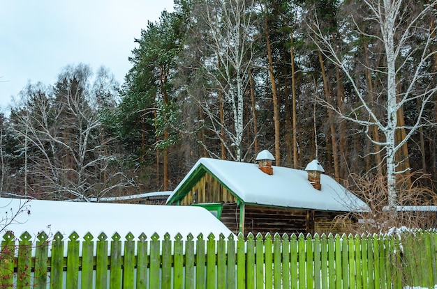 Ein kleines Holzhaus im Wald im Winter unter dem Schnee.