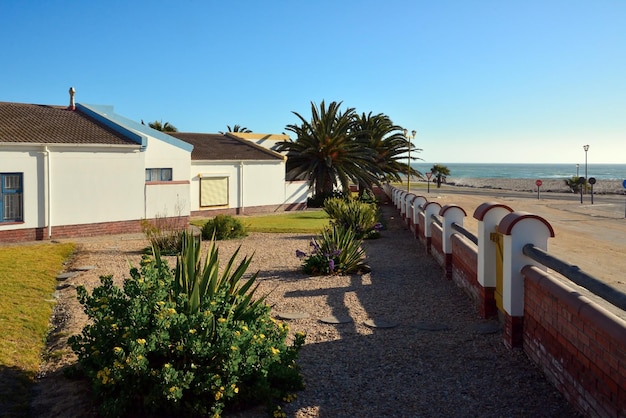 Ein kleines Hotel am Strand oder Meer mit Zäunen und Blumenbeeten