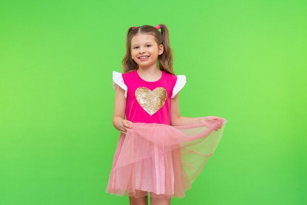 Ein kleines hübsches Mädchen mit lockigem Haar. Ein Mädchen in einem rosa Kleid.