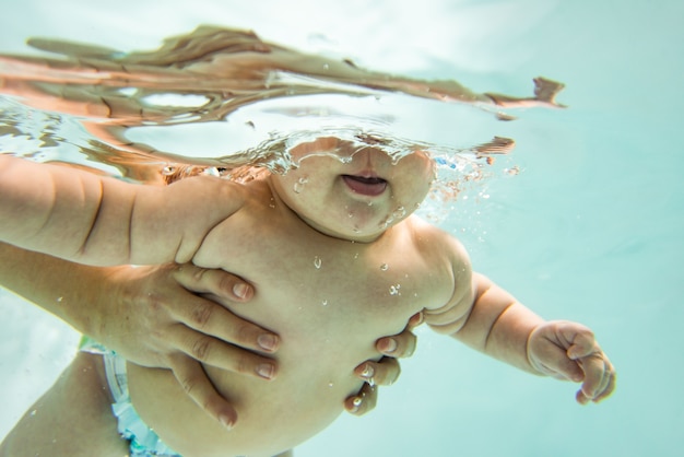 Foto ein kleines kind schwimmt unter wasser.