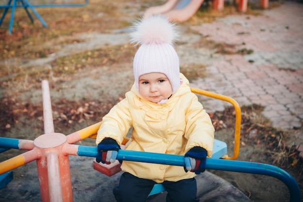 Ein kleines Mädchen, das auf dem Spielplatz der Stadt der Kinder spielt. Ein kleines Kind reitet den Hügel hinunter, klettert auf dem Karussell die Seile hoch. Unterhaltungsindustriekonzept, Familientag, Parks der Kinder