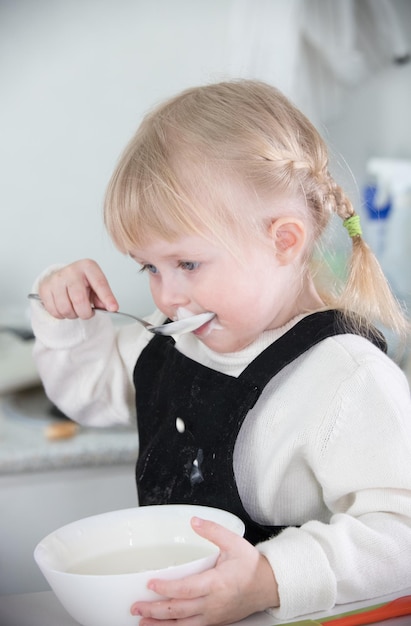 Ein kleines Mädchen, das eine saure Sahne isst