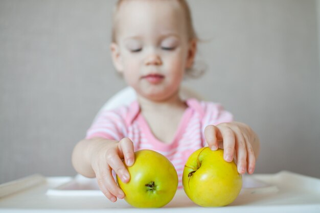 Ein kleines Mädchen, das frische Äpfel berührt