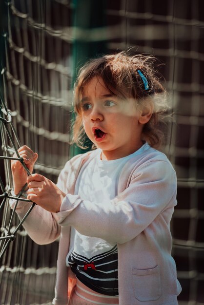 Ein kleines Mädchen, das im Park spielt. Das Konzept der Familiensozialisierung im Park. Ein Mädchen schwingt auf einer Schaukel, spielt kreative Spiele.