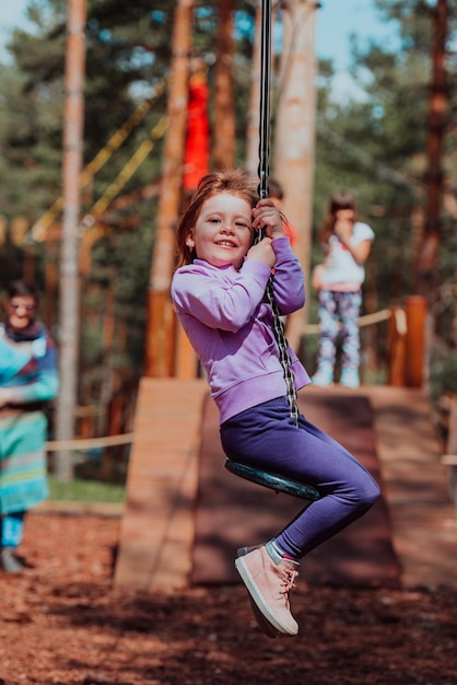 Ein kleines Mädchen, das im Park spielt. Das Konzept der Familiensozialisierung im Park. Ein Mädchen schwingt auf einer Schaukel, spielt kreative Spiele.