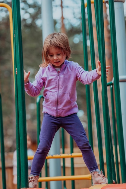 Ein kleines Mädchen, das im Park spielt. Das Konzept der Familiensozialisierung im Park. Ein Mädchen schwingt auf einer Schaukel, spielt kreative Spiele.