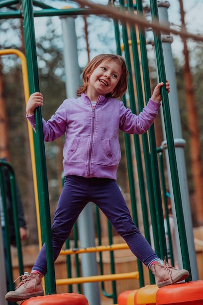 Ein kleines Mädchen, das im Park spielt. Das Konzept der Familiensozialisierung im Park. Ein Mädchen schwingt auf einer Schaukel, spielt kreative Spiele.