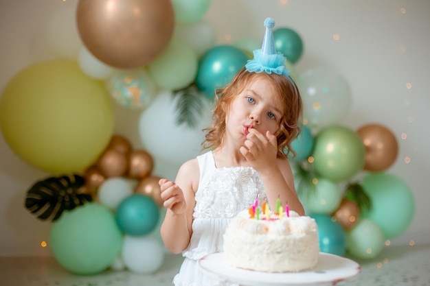Ein kleines Mädchen feiert Geburtstag und probiert einen Kuchen