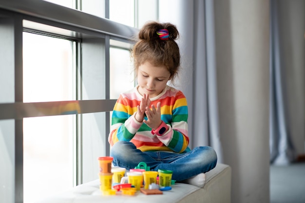 Foto ein kleines mädchen formt aus plastilin