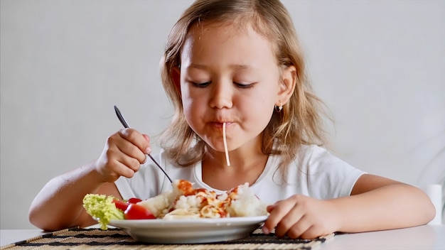 Ein kleines Mädchen isst zu Hause Spaghetti