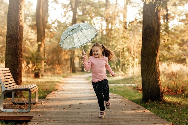 Ein kleines Mädchen läuft mit einem Regenschirm in der Hand