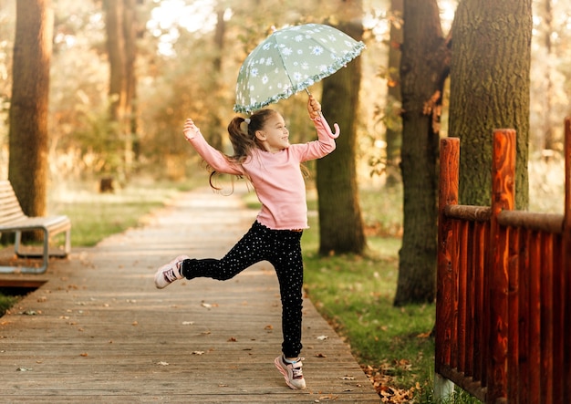 Ein kleines Mädchen läuft mit einem Regenschirm in der Hand