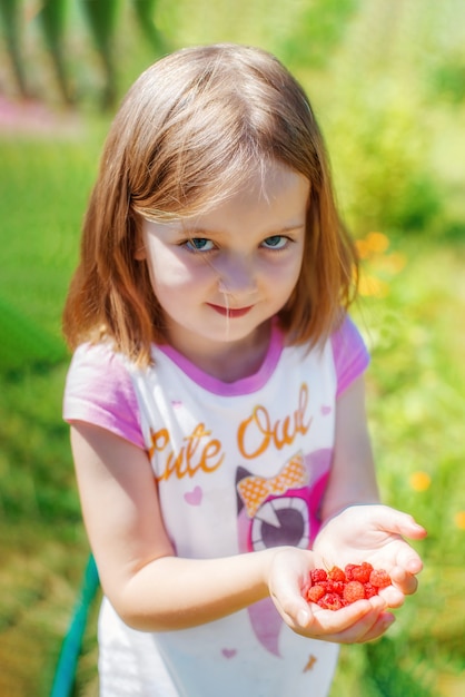 Ein kleines Mädchen mit Beeren in den Händen