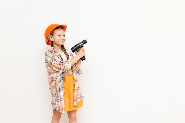 Ein kleines Mädchen mit einem Bohrer in den Händen, um Ihre Werbung auf einem weißen, isolierten Hintergrund zu zeigen Das Konzept der Renovierung im Kinderzimmer Kopieren Sie Platz