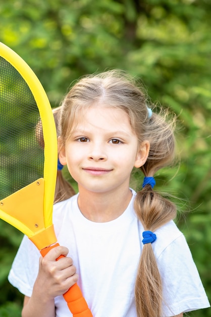 Ein kleines Mädchen mit einem Tennisschläger für Kinder in den Händen