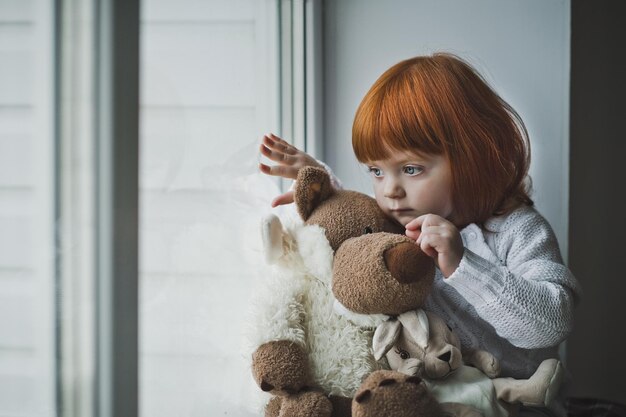 Ein kleines Mädchen mit roten Haaren spielt mit Spielzeug 4386