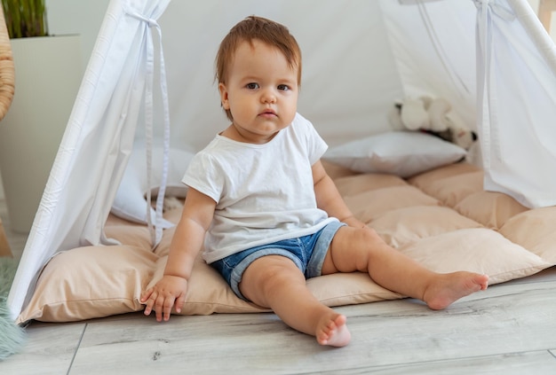 Ein kleines Mädchen sitzt zu Hause in einem Wigwam