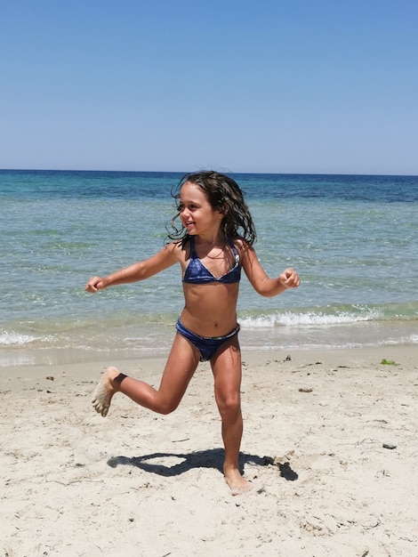 Ein kleines Mädchen spielt am Strand