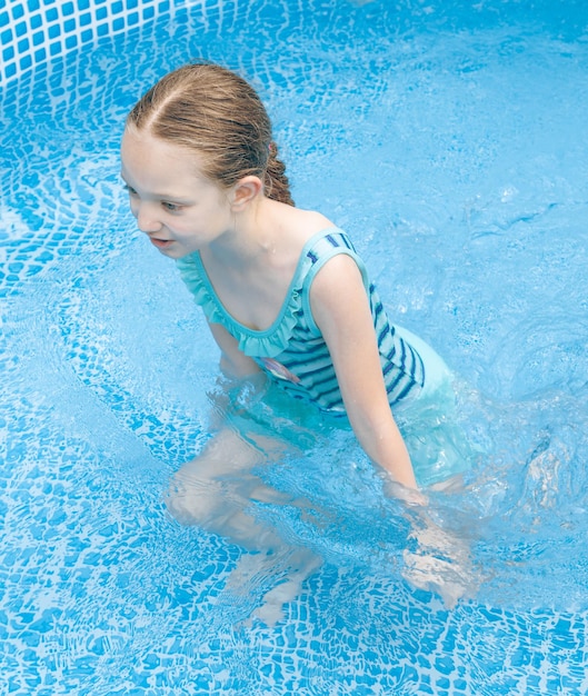 Ein kleines Mädchen spielt im Pool