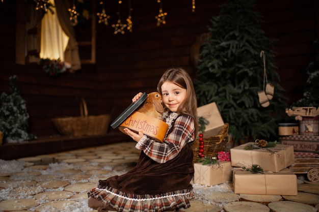 Ein kleines Mädchen spielt mit ihrem Hasenfreund in einer fabelhaften Weihnachtsnacht