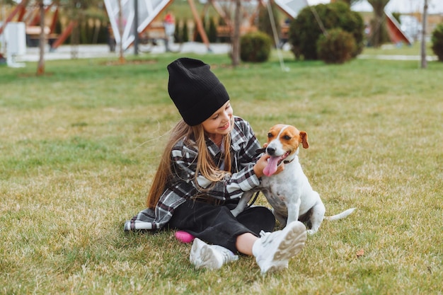 Ein kleines Mädchen spielt mit ihrem Hund auf dem Rasen im Park Jack Russell Terrier ein Kind gibt seinem Hund ein Spielzeug