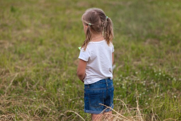 Ein kleines Mädchen steht im Gras