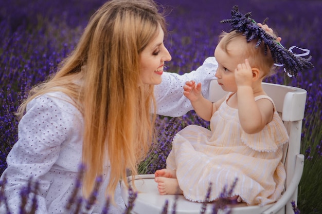 Ein kleines Mädchen und ihre Mutter posieren mit einem Lavendelkranz, wenn sie zusammen sind