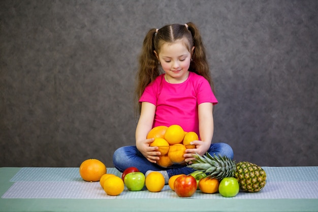 Ein kleines Mädchen von sechs Jahren liebt Früchte sehr. Vitamine und gesunde Ernährung.