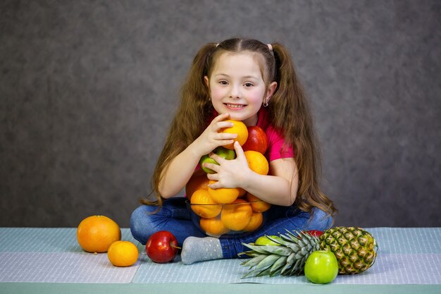 Ein kleines Mädchen von sechs Jahren liebt Früchte sehr. Vitamine und gesunde Ernährung.