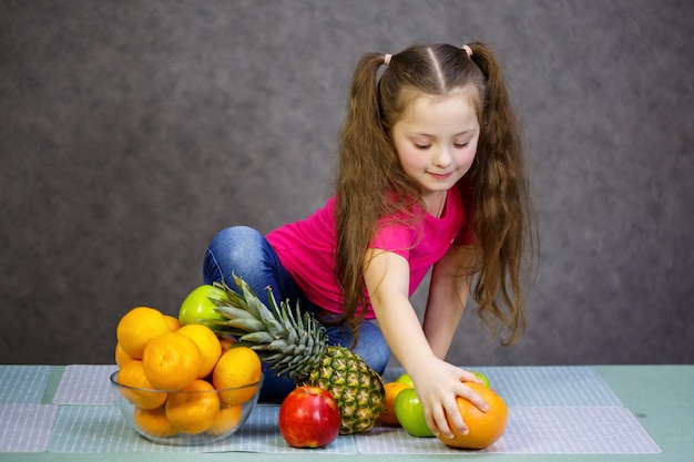 Ein kleines Mädchen von sechs Jahren liebt Früchte sehr. Vitamine und gesunde Ernährung.