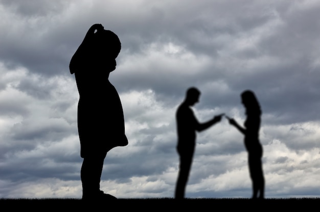 Ein kleines Mädchen weint und sieht, wie sich ihre Eltern ständig streiten. Das Konzept von familiären Konflikten und Meinungsverschiedenheiten