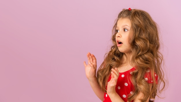 Ein kleines Mädchen zeigt einen Schreck auf einem lila Hintergrund.