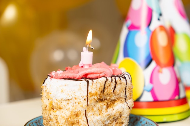 Ein kleines Stück Kuchen mit einer brennenden Geburtstagskerze
