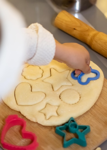 Ein kleines süßes Mädchen macht Weihnachtsplätzchen. Haus. Neujahr. Kompfort.